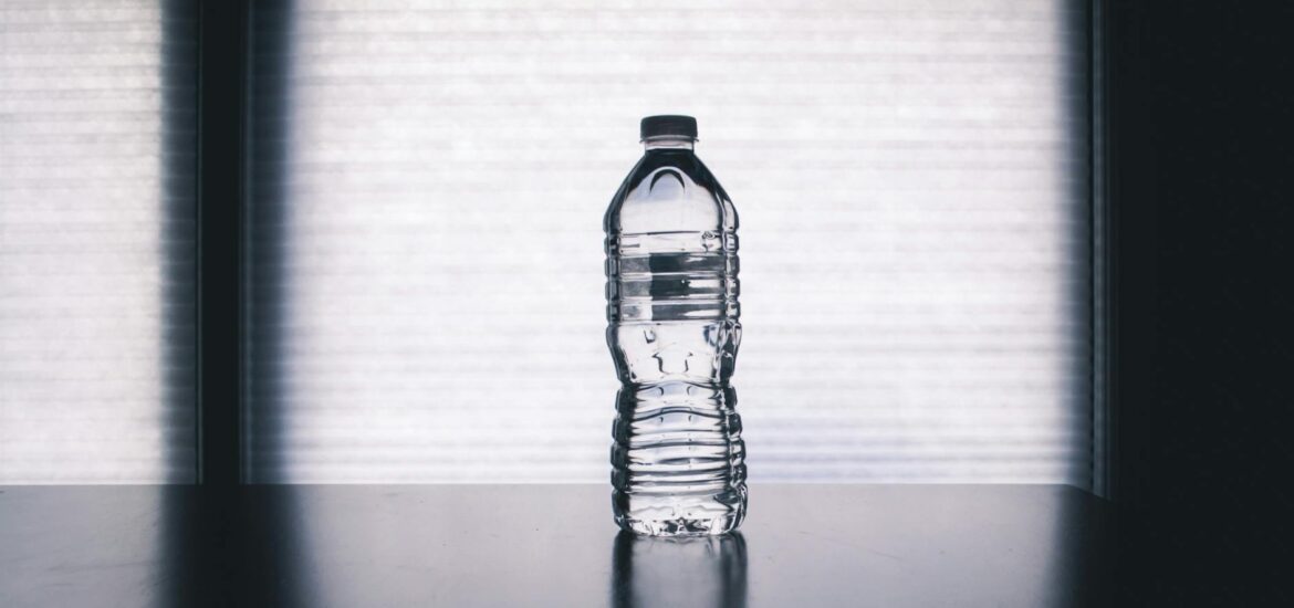 clear disposable bottle on black surface