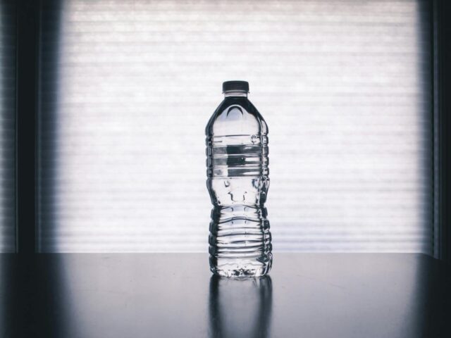 clear disposable bottle on black surface