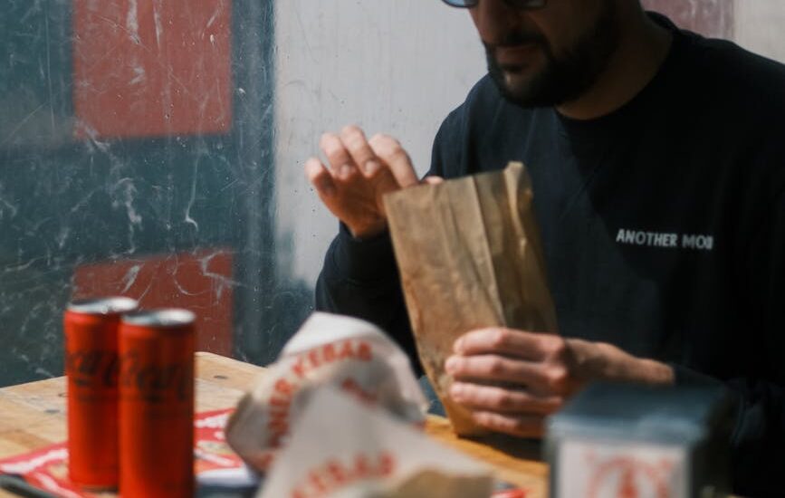 a man sitting at a table and eating street food